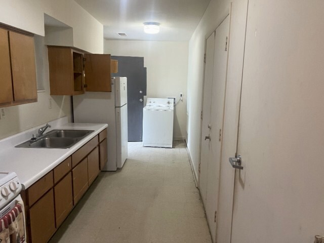 New kitchen with washing machine at the end of the room.