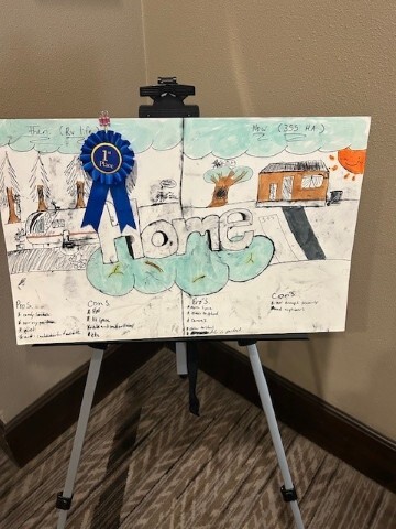 Xavion Reaves poster artwork on an easel with a 1st place ribbon. 