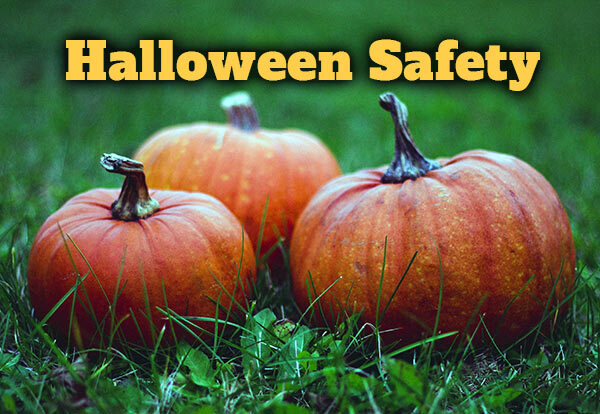 The words "Halloween Safety" and three pumpkins sitting in grass.