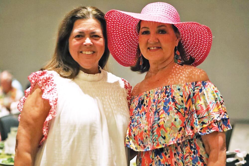 Kathy Cribbs and Beverly Gasque stand with their arms around one another and smile broad smiles.
